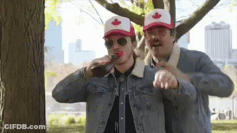 Two Men Wearing Hats With A Maple Leaf On Them Drinking From A Bottle GIF