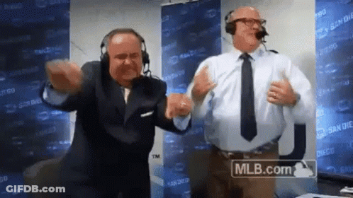 Two Men Wearing Headphones And Ties Are Dancing In Front Of A Mlb.com Sign . GIF