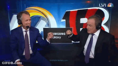 Two Men Wearing Headphones Are Sitting In Front Of A Screen That Says Samsung Galaxy GIF