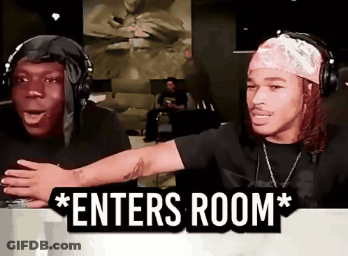 Two Men Wearing Headphones Are Sitting In Front Of A Sign That Says " Enters Room " . GIF