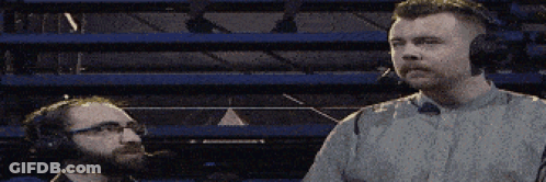 Two Men Wearing Headphones Are Standing Next To Each Other In A Stadium GIF