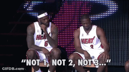 Two Men Wearing Heat Jerseys Are Sitting On A Stage GIF