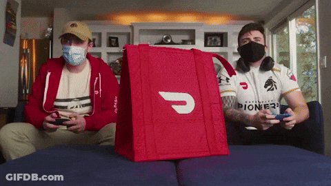 Two Men Wearing Masks Are Playing A Video Game With A Red Bag That Says Pioneer On It GIF