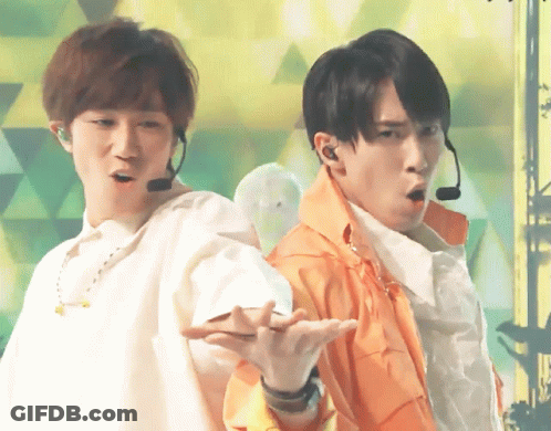 Two Men Wearing Microphones Are Standing Next To Each Other In Front Of A Green Background GIF
