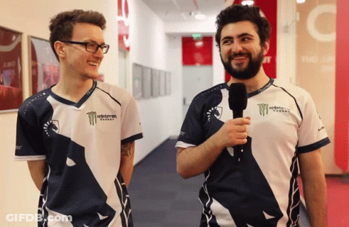 Two Men Wearing Monster Energy Shirts Are Standing Next To Each Other In A Hallway GIF