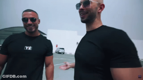 Two Men Wearing Sunglasses And Black Shirts With Ye On Them GIF