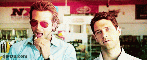Two Men Wearing Sunglasses Are Standing Next To Each Other In Front Of A Store That Says N7 GIF