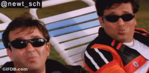 Two Men Wearing Sunglasses Sit Next To Each Other In A Chair GIF