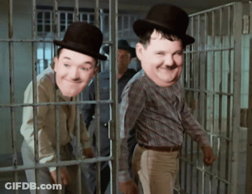 Two Men Wearing Top Hats Are Behind Bars GIF