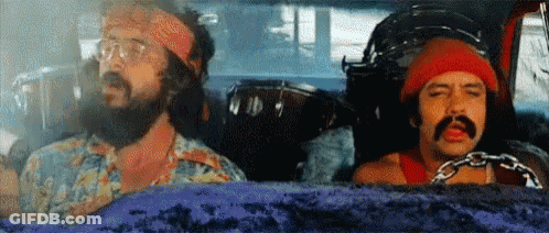 Two Men With Beards And Mustaches Are Sitting In A Car . One Of The Men Has A Chain Around His Neck . GIF