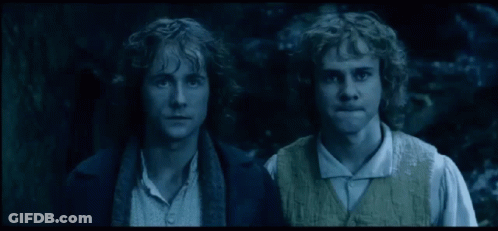 Two Men With Curly Hair Standing In The Dark GIF