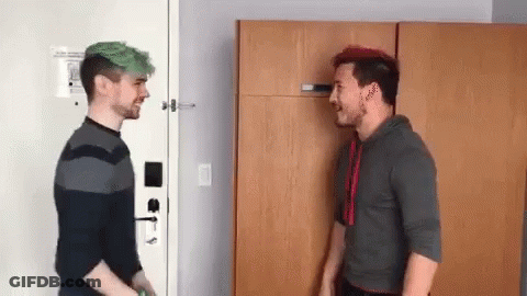 Two Men With Green Hair Are Standing Next To Each Other In A Room And Talking To Each Other . GIF