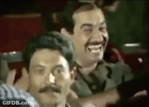 Two Men With Mustaches Laughing In Theater GIF