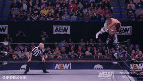 Two Men Wrestling In A Ring On Saturday May 18 GIF