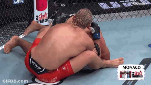 Two Men Wrestling In Front Of 2 Shots Sign GIF