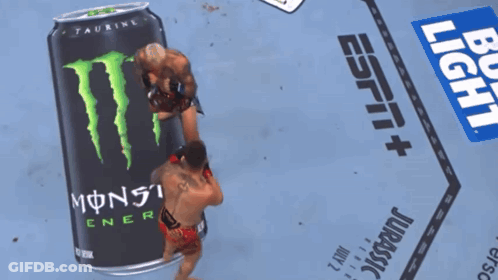 Two Men Wrestling In Front Of Monster Energy Can GIF