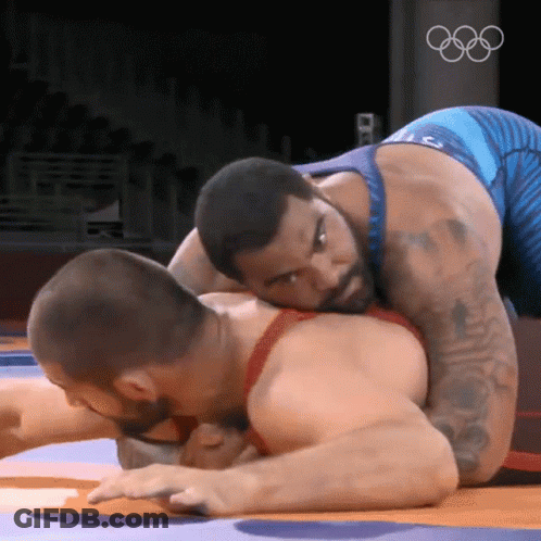 Two Men Wrestling In Front Of Olympic Logo GIF