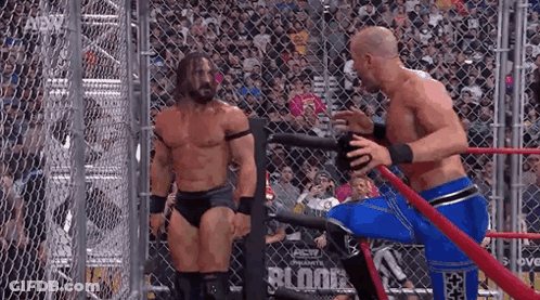 Two Men Wrestling In Ring Behind Chain Link Fence GIF