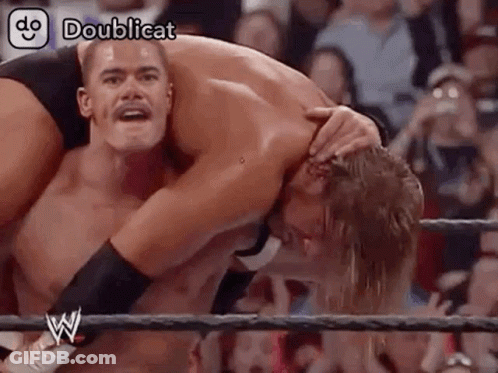 Two Men Wrestling In Ring Holding Head GIF