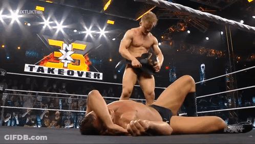 Two Men Wrestling With Takeover Sign GIF