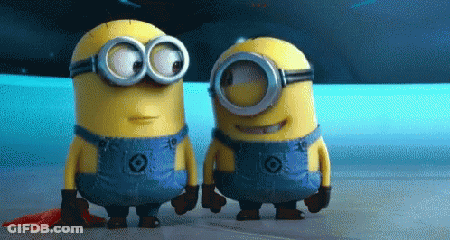 Two Minions Standing Together One In Overalls And Goggles GIF
