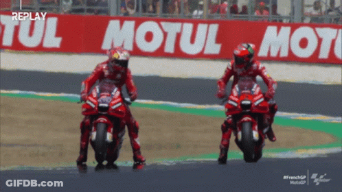 Two Motorcycle Racers On Track With Motul Sign GIF