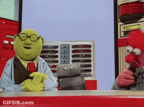 Two Muppets Are Sitting At A Table And One Is Wearing Glasses And A Tie GIF