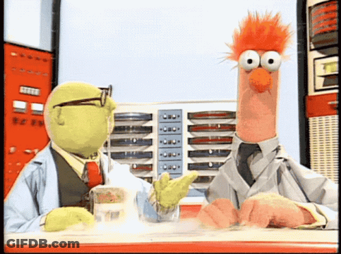 Two Muppets Are Sitting At A Table And One Of Them Is Wearing A Lab Coat GIF