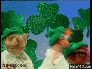 Two Muppets In Green Hats With Shamrocks GIF