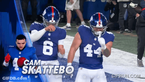 Two New York Giants Football Players Are Standing On A Field GIF