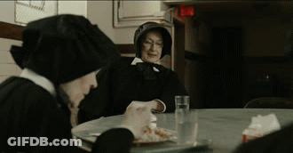 Two Nuns Sit At A Table Eating Food And Drinking Water GIF