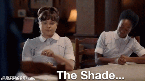 Two Nurses Are Sitting At A Table With The Words The Shade Written On The Bottom GIF