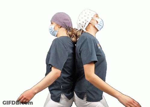 Two Nurses In Scrubs And Masks Dancing GIF
