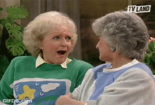 Two Older Women Are Sitting Next To Each Other And One Is Wearing A Green Sweater And The Other Is Wearing A Blue Shirt GIF