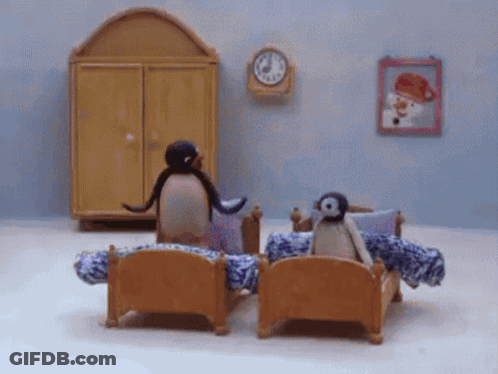 Two Penguins Sitting On Bed GIF