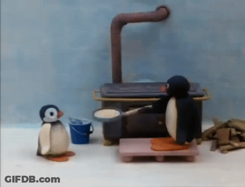Two Penguins Standing By Stove GIF