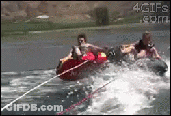 Two People Are Being Towed By A Boat In The Water And The Website 4Gifs.com Is Visible On The Bottom GIF