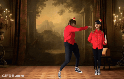 Two People Are Dancing In Front Of A Painting On The Wall GIF