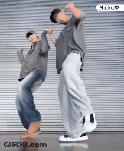Two People Are Dancing In Front Of A Wall And The Word Mika Is On The Bottom GIF