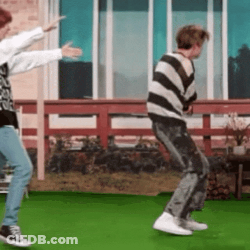 Two People Are Dancing On A Green Field . GIF