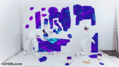Two People Are Painting On A White Wall With Purple And Blue Paint . GIF