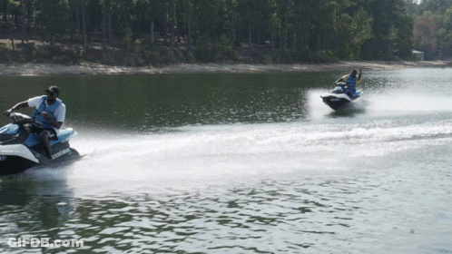 Two People Are Riding Jet Skis On A Lake And One Of The Jet Skis Has The Word Sea Doo On It GIF