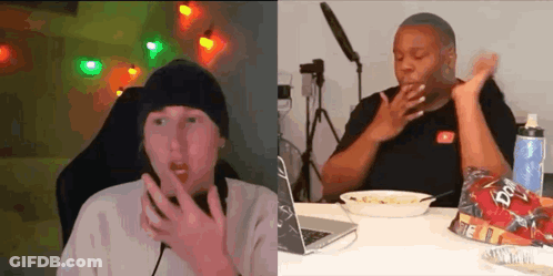Two People Are Sitting At A Table With A Laptop And A Bowl Of Food . GIF
