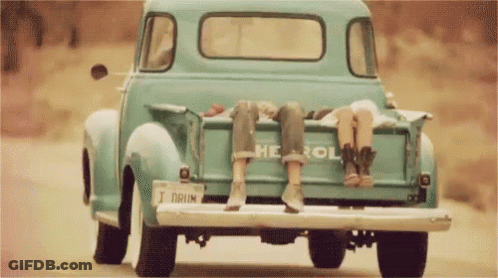 Two People Are Sitting In The Back Of A Blue Chevrolet Truck GIF