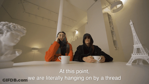 Two People At Table Hanging On By A Thread GIF