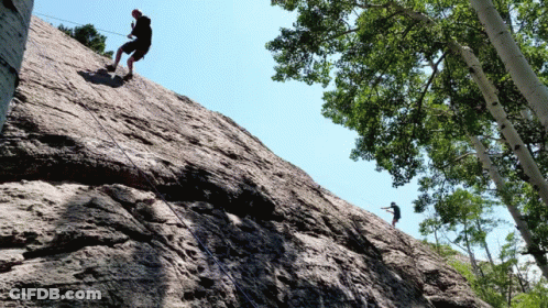 Two People Climbing Rocky Cliff GIF