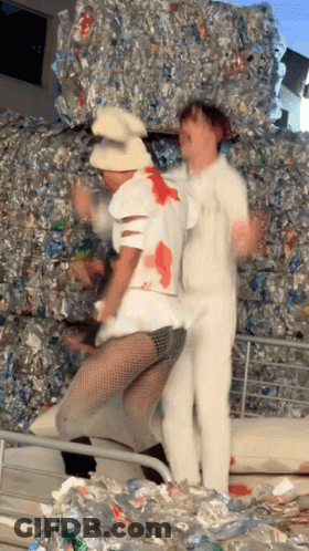 Two People Dancing In Front Of Empty Plastic Bottles GIF