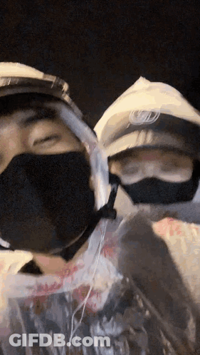 Two People In Face Masks One With Helmet GIF