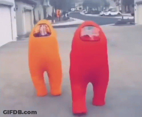 Two People In Orange And Red Among Us Costumes Standing On Street GIF
