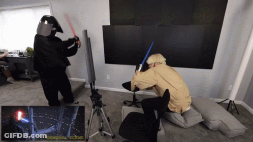 Two People In Star Wars Costumes Fighting With Lightsabers GIF